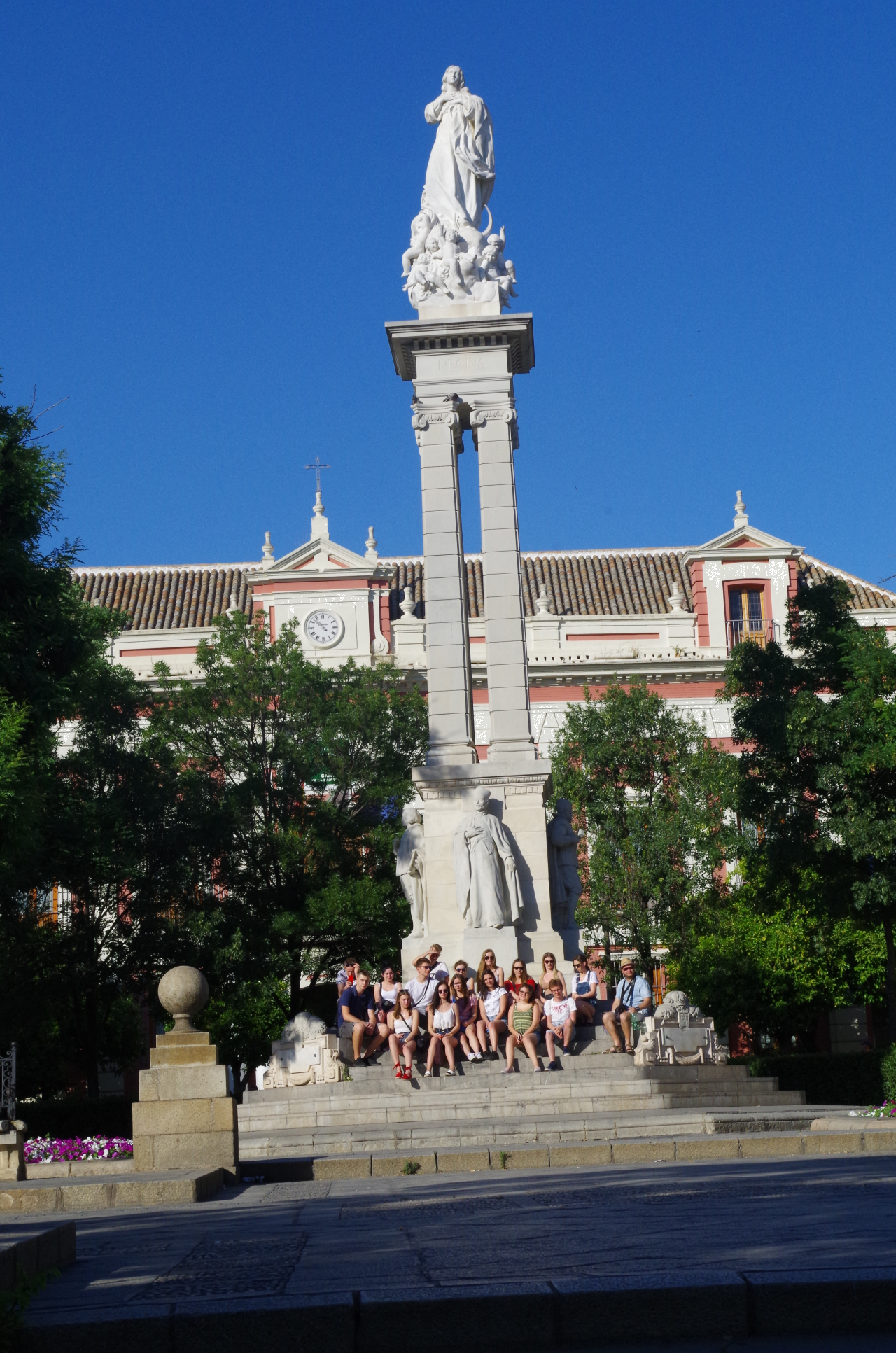 Uczniowie pod pomnikiem na Plaze del Triunfo w Sevilli
